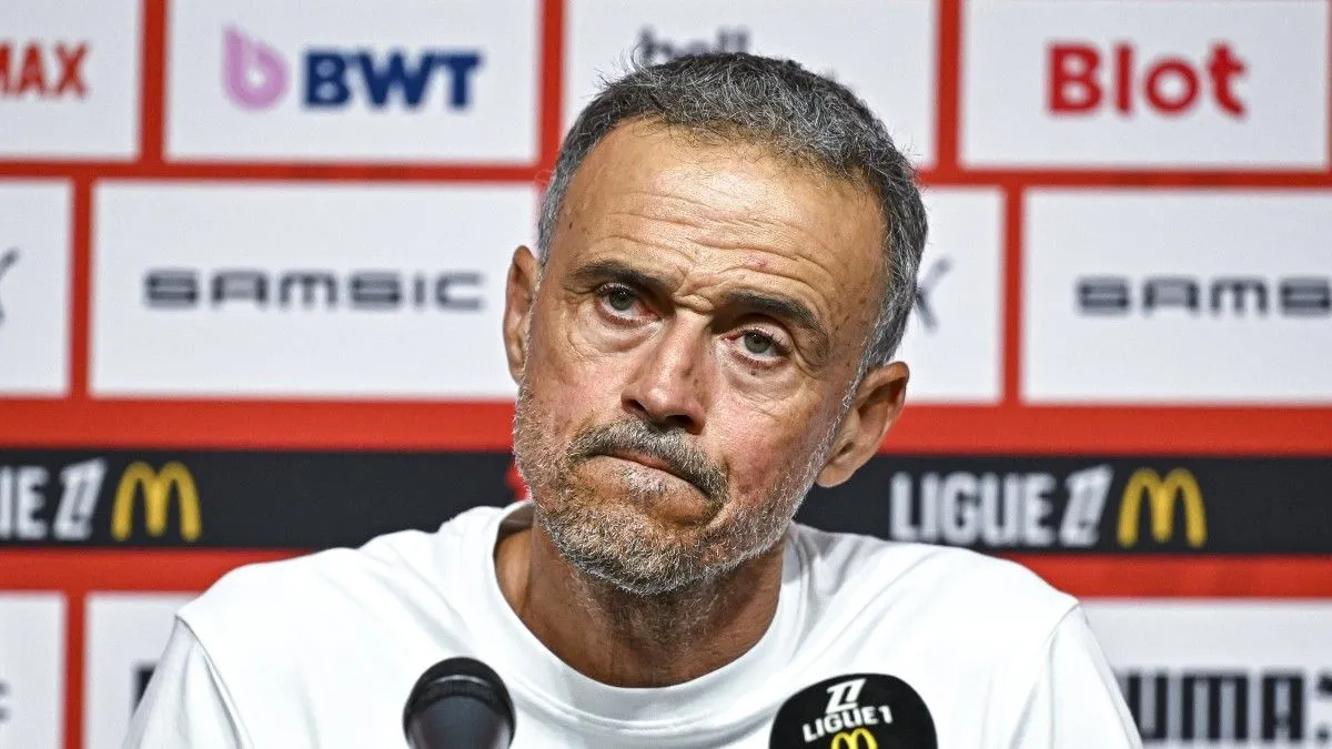 Luis Enrique tersenyum saat menandatangani kontrak baru bersama PSG di pusat pelatihan.
