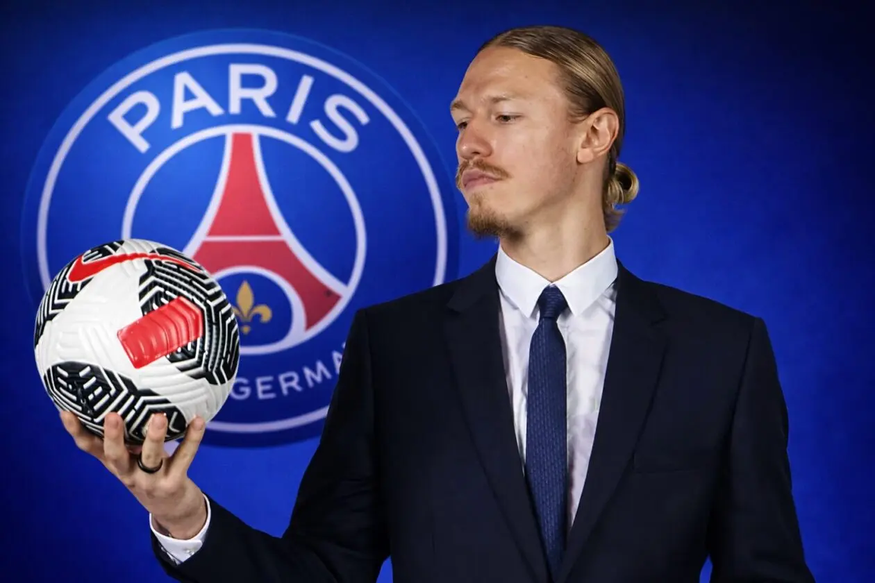 Matvei Safonov tersenyum mengenakan jaket PSG di depan Arc de Triomphe