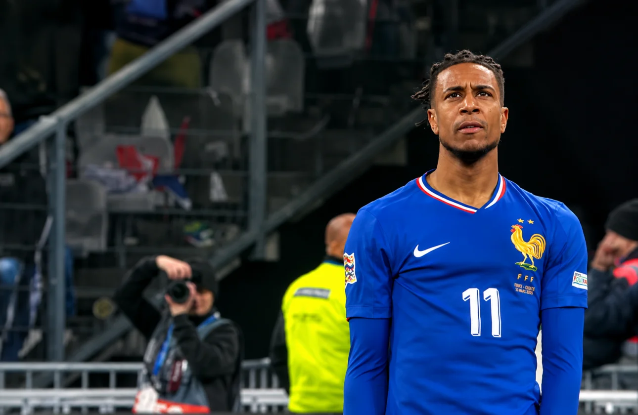 Michael Olise membela Bayern Munich saat pertandingan dengan latar stadion dan suporter