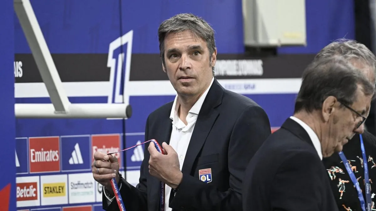 Logo Olympique Lyonnais dengan latar belakang stadion Parc OL saat konferensi pers.