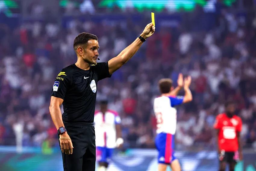 Wasit Mathieu Vernice memberikan kartu kuning dalam pertandingan Ligue 1 antara PSG dan Le Mans di Parc des Princes.